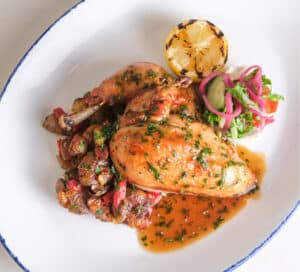 Photo of Gerber Amish Farms roasted half chicken with lemon-thyme jus, fingerling potato hash, and lemon.