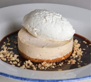 Photo of peanut butter cremeaux dessert with Nutter Butter® crust, chocolate fudge sauce, whipped cream, and peanut tuille.