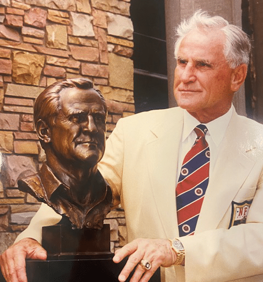 Vintage photo of NFL coach Don Shula posing with bronze bust of his likeness.
